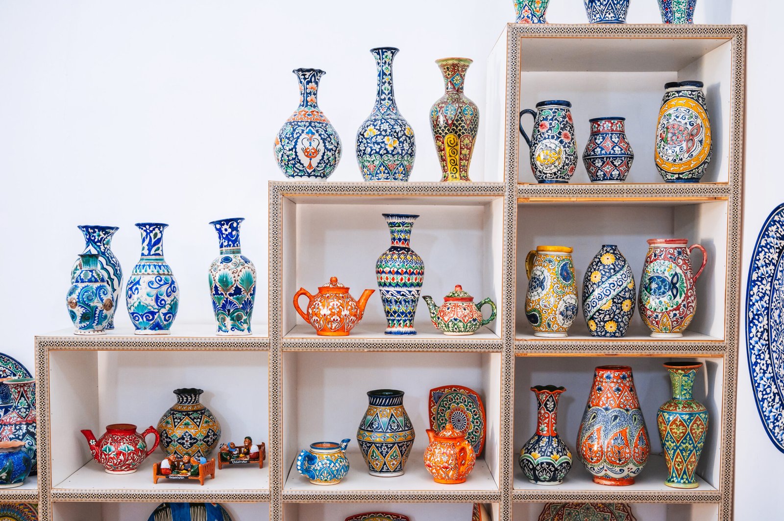 uzbek-ceramic-vases-with-handpainted-traditional-asian-colorful-patterns-shelves-white-background-scaled.jpg